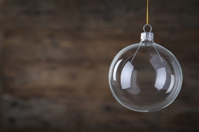 Photo of Transparent glass Christmas ball on blurred background. Space for text