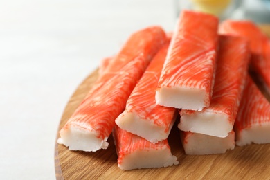 Fresh crab sticks on wooden cutting board, closeup