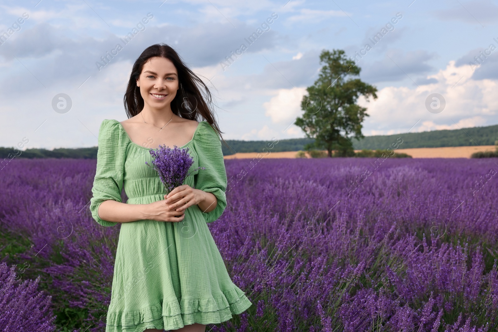 Photo of Smiling woman with bouquet in lavender field. Space for text