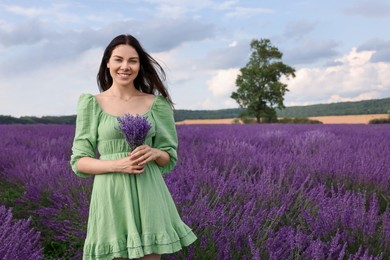 Smiling woman with bouquet in lavender field. Space for text