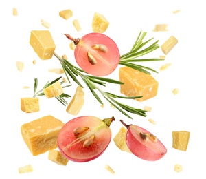 Pieces of delicious parmesan, grapes and rosemary falling on white background