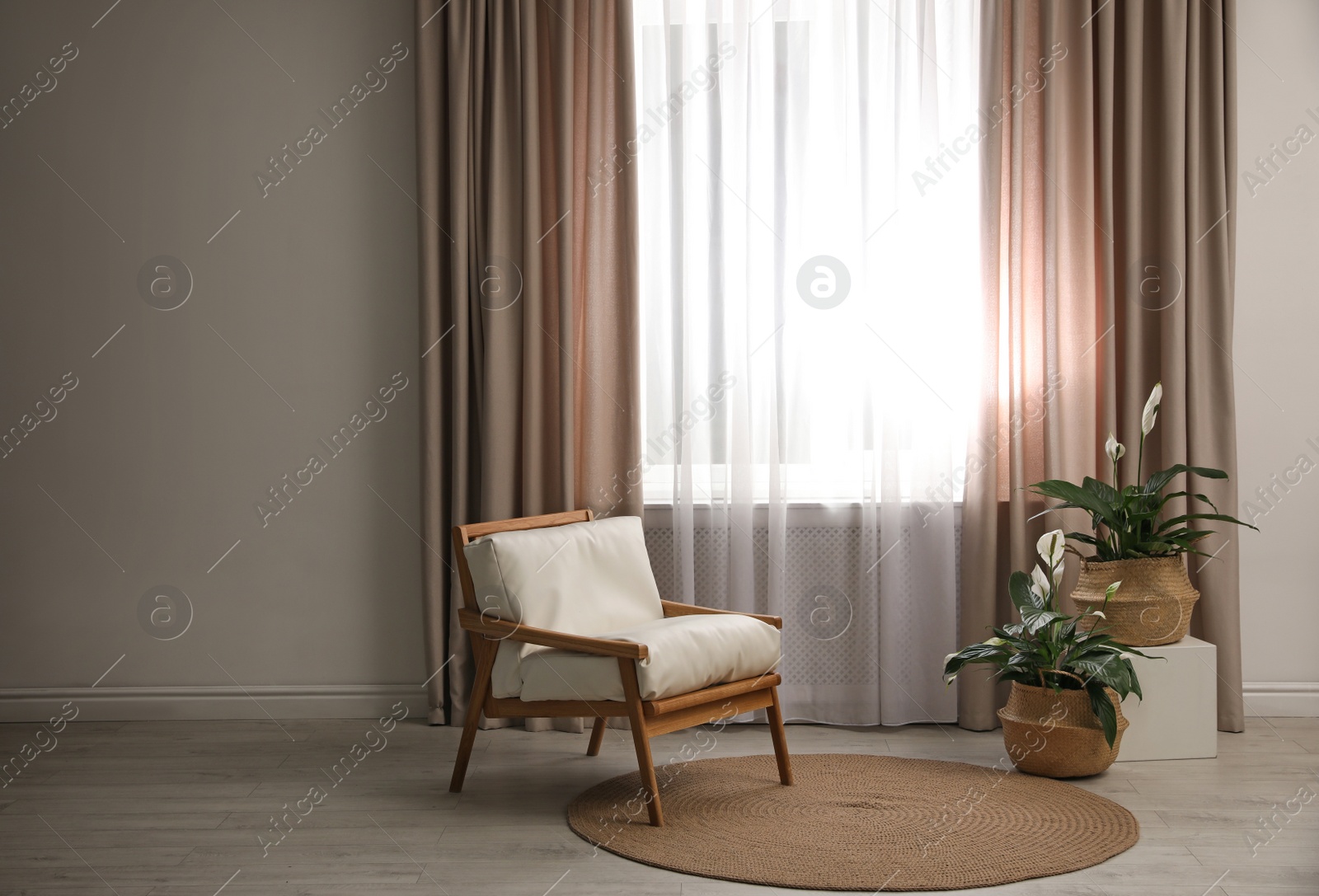 Photo of Comfortable armchair near window with elegant curtains in room