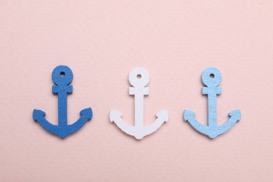 Anchor figures on pale pink background, flat lay