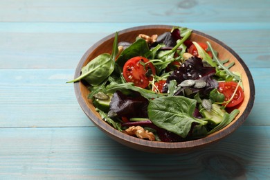 Photo of Tasty fresh vegetarian salad on light blue wooden table. Space for text