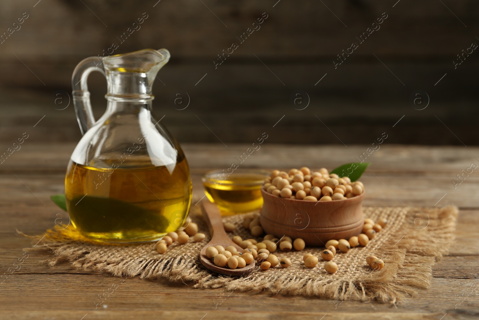 Photo of Composition with soybean oil on wooden table