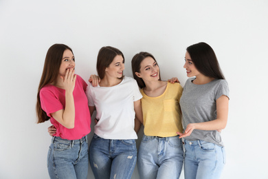 Photo of Beautiful young ladies in jeans and colorful t-shirts on white background. Woman's Day