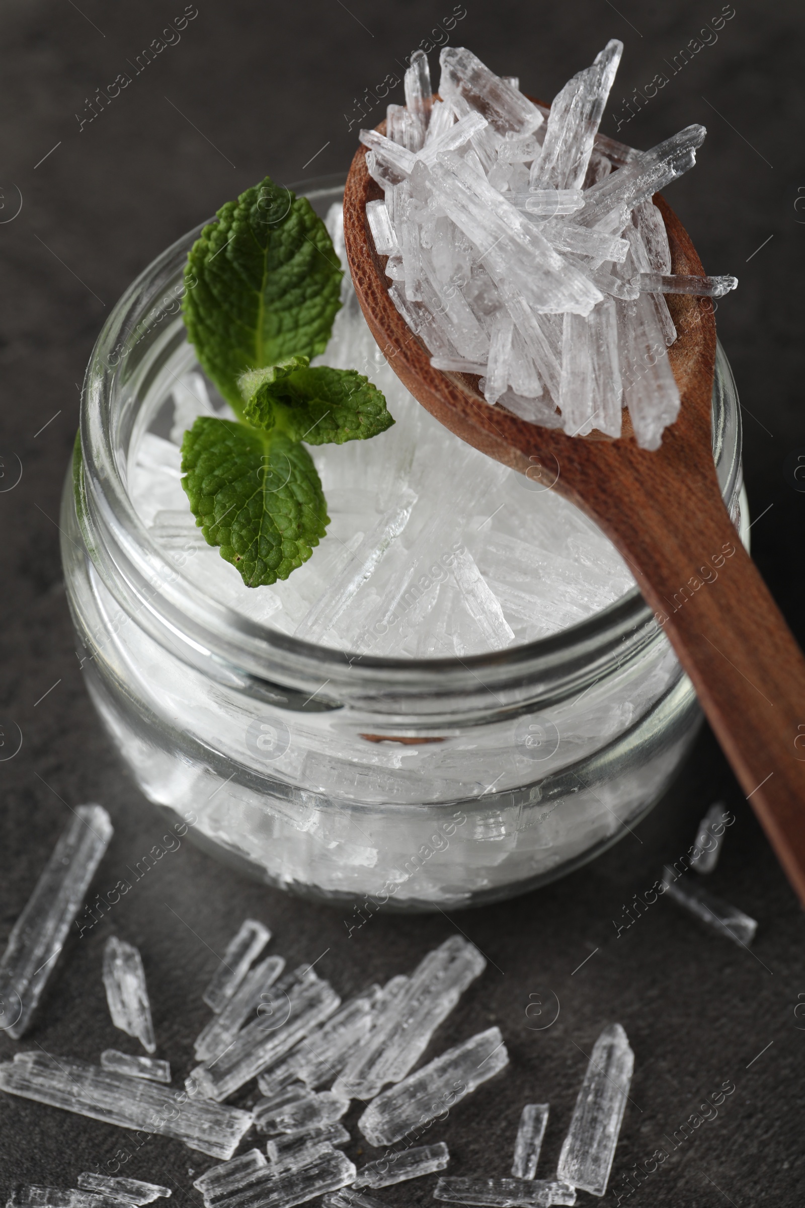 Photo of Menthol crystals and mint leaves on grey background