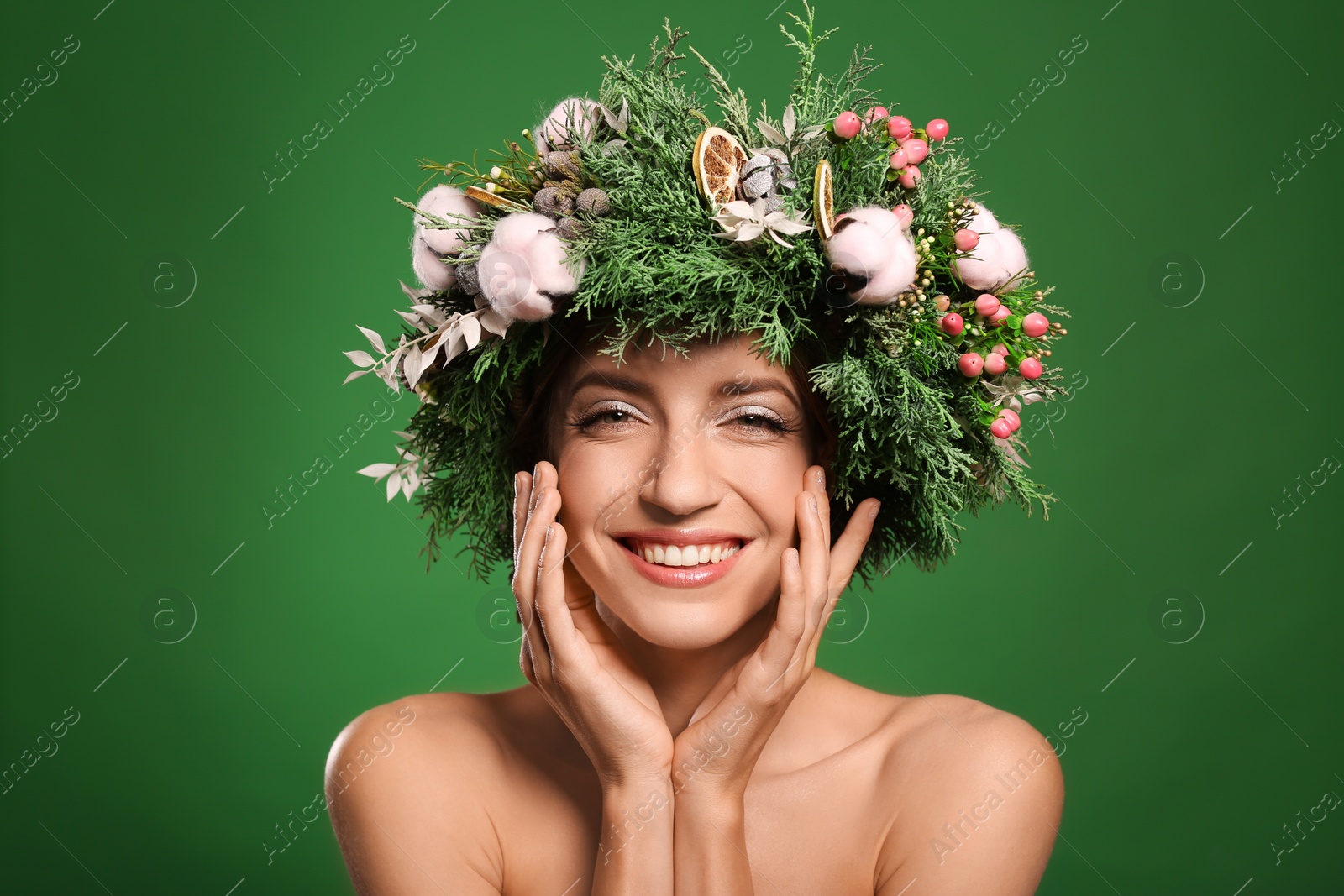 Photo of Happy young woman wearing wreath on green background