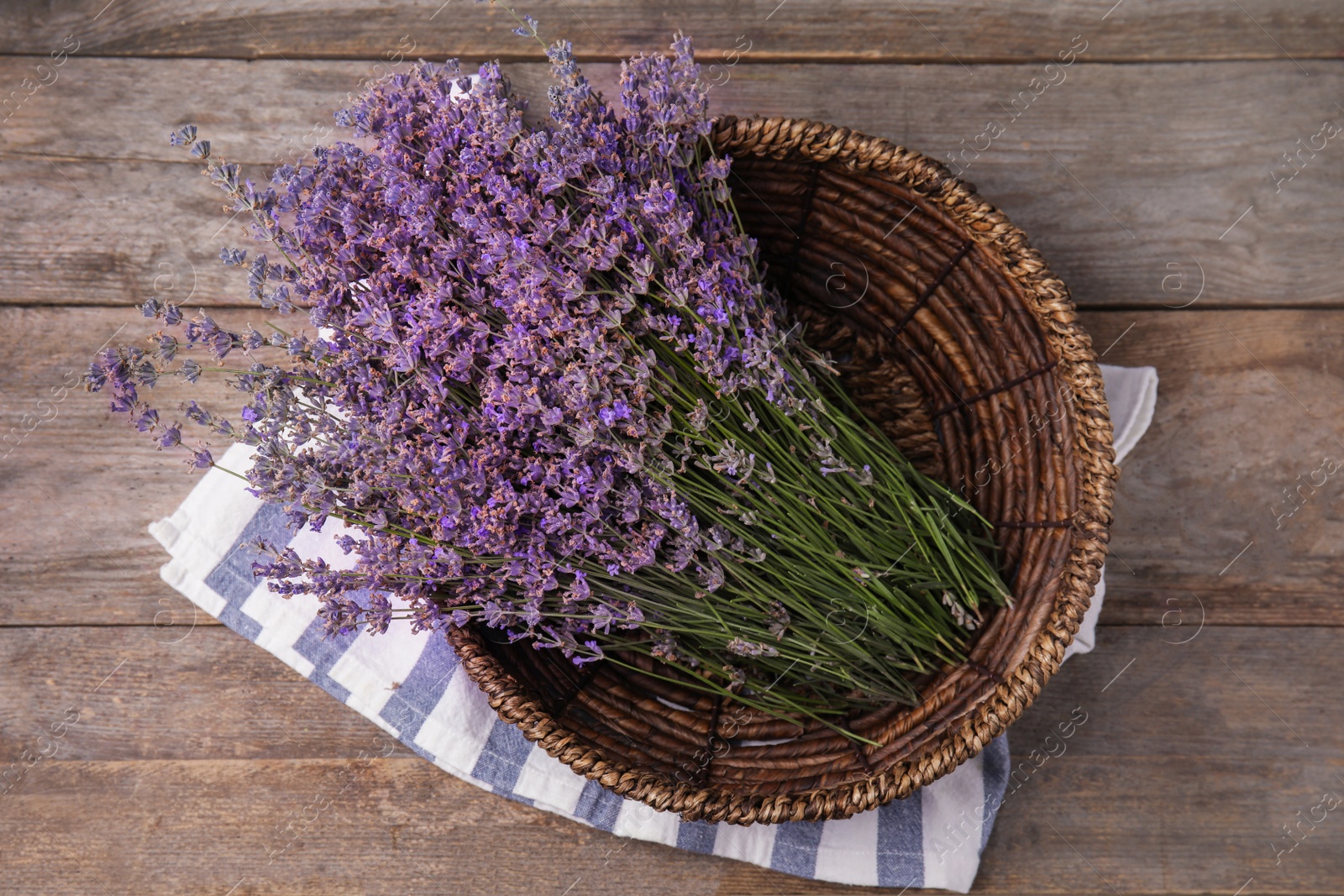 Photo of Bowl with lavender flowers on wooden table, top view