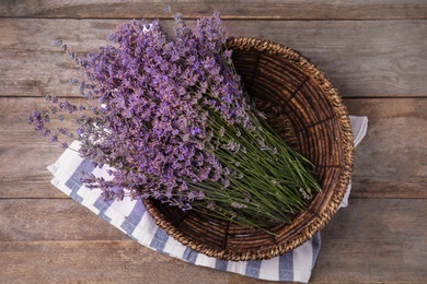 Bowl with lavender flowers on wooden table, top view