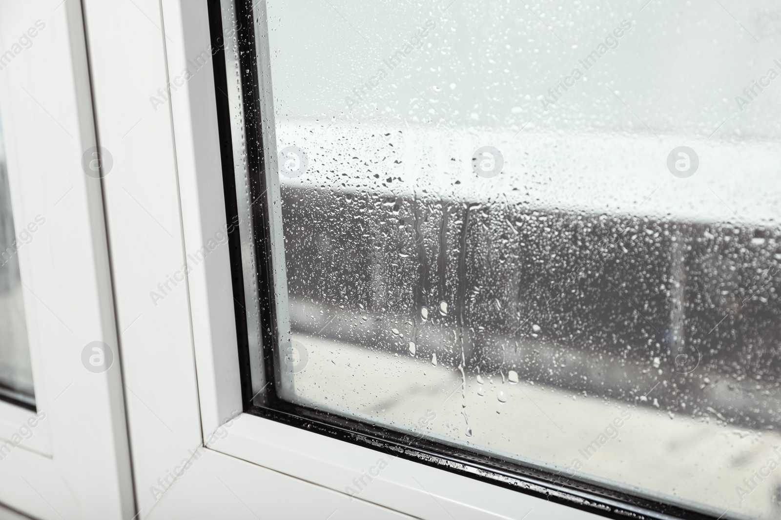 Photo of Window glass with drops of condensate indoors, closeup