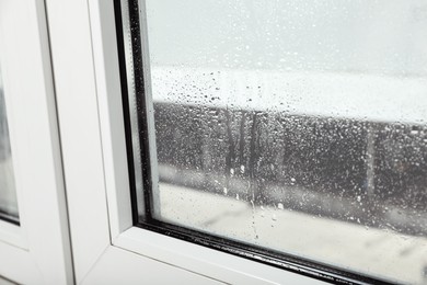 Window glass with drops of condensate indoors, closeup