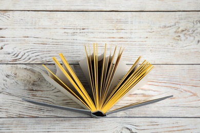 Photo of Hardcover book on white wooden background, top view