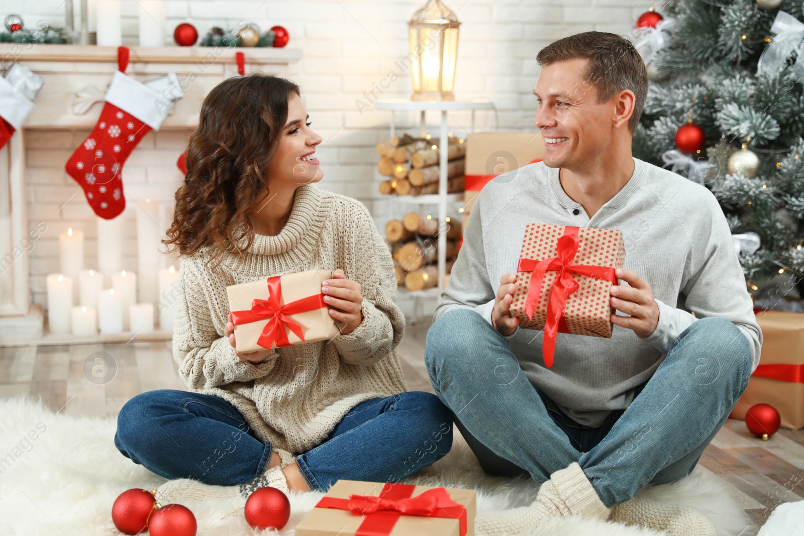 Image of Happy couple with Christmas gifts at home