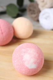 Photo of Beautiful aromatic bath bomb on wooden board, closeup