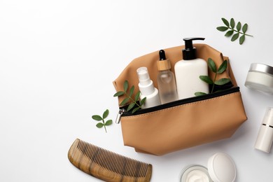 Photo of Preparation for spa. Compact toiletry bag with cosmetic products, comb and twigs on white background, top view. Space for text