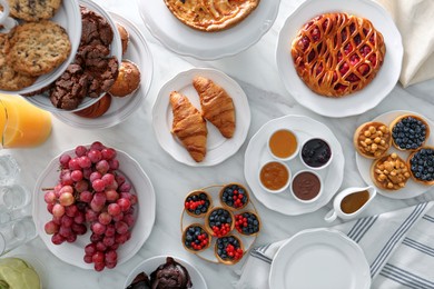 Photo of Variety of snacks on white marble table in buffet style, flat lay