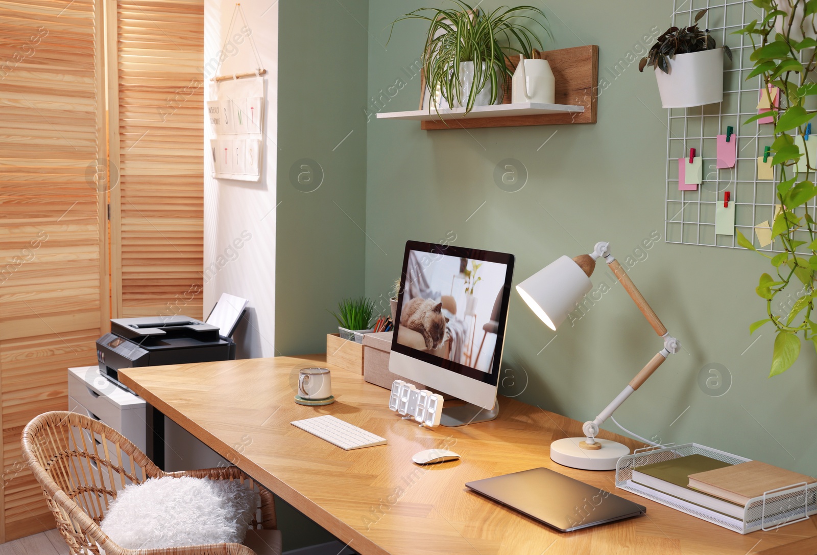 Photo of Stylish workplace with computer, laptop and lamp near olive wall at home