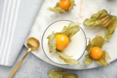 Photo of Delicious dessert decorated with physalis fruit on light grey table, flat lay