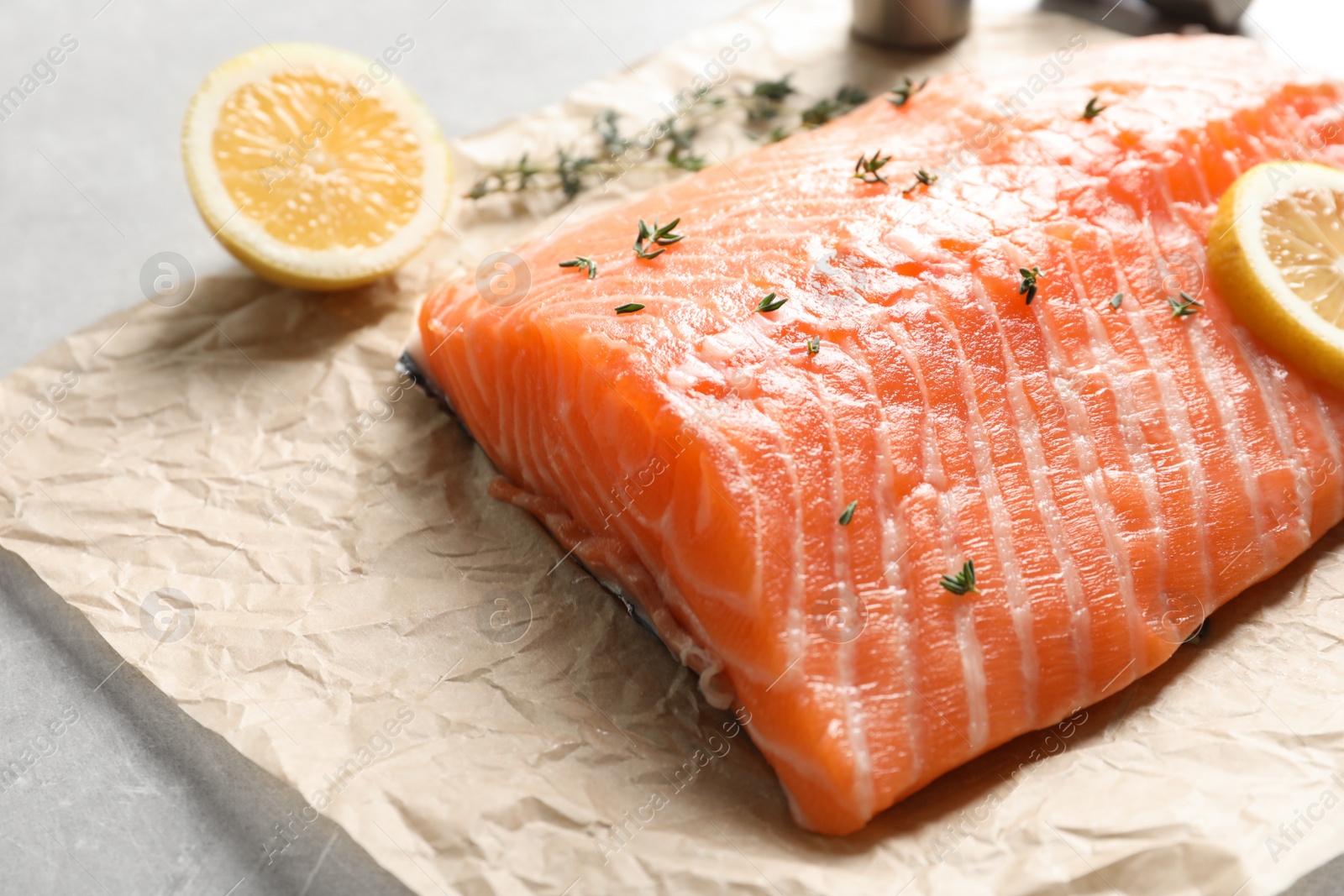 Photo of Raw salmon fillet with lemon and thyme for marinade on table