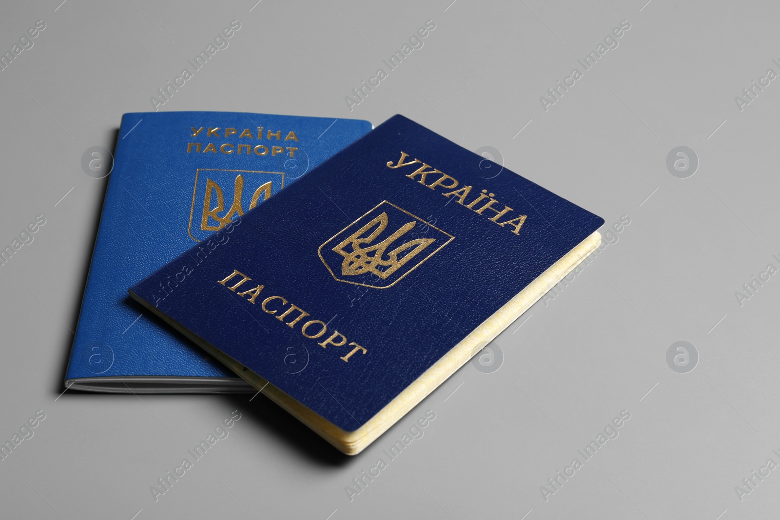 Photo of Ukrainian passports on grey background. International relationships
