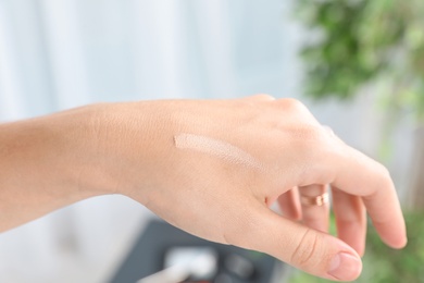 Woman testing foundation tone on hand, closeup