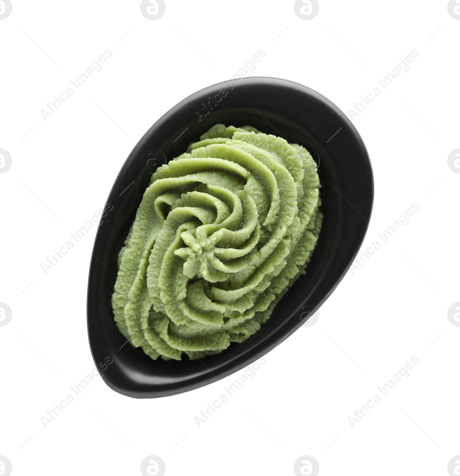 Photo of Bowl with swirl of wasabi paste isolated on white, top view