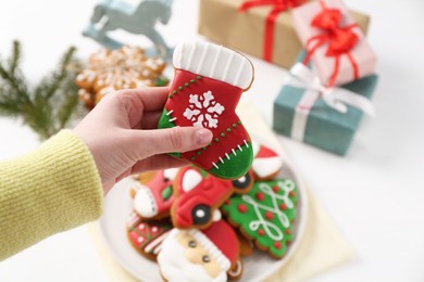 Woman with decorated Christmas cookie at table, above view