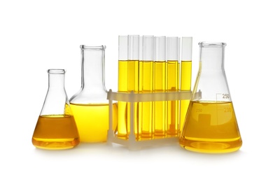 Laboratory glassware with yellow liquid on white background