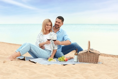 Photo of Happy romantic couple having picnic at beach