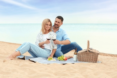 Happy romantic couple having picnic at beach