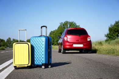 Photo of Color suitcases near family car on highway. Summer vacation