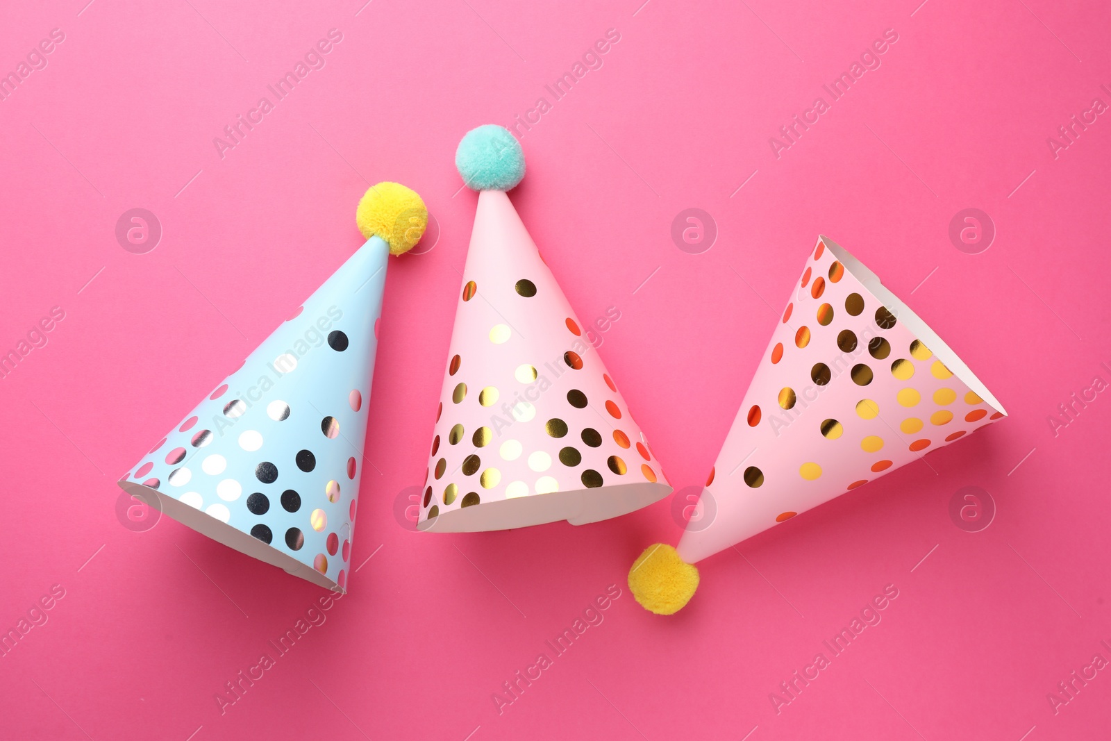 Photo of Beautiful party hats on pink background, top view