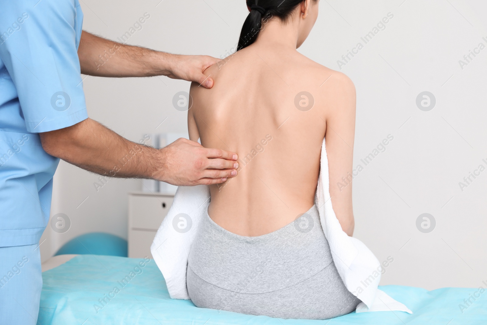 Photo of Orthopedist examining woman's back in clinic, closeup. Scoliosis treatment