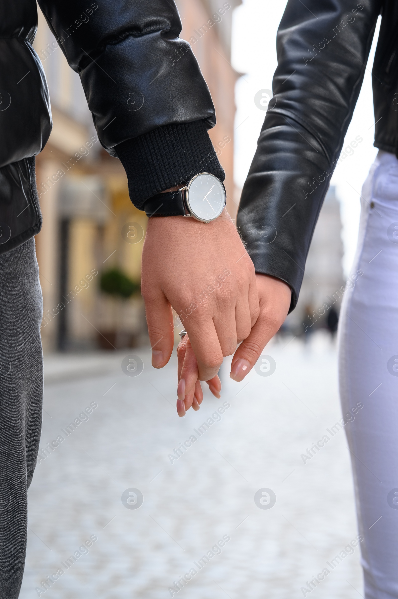 Photo of Lovely couple holding hands together outdoors, closeup. Romantic date