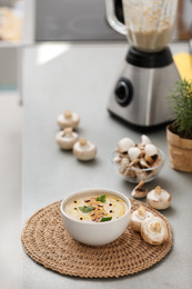 Delicious cream soup with mushrooms on grey table