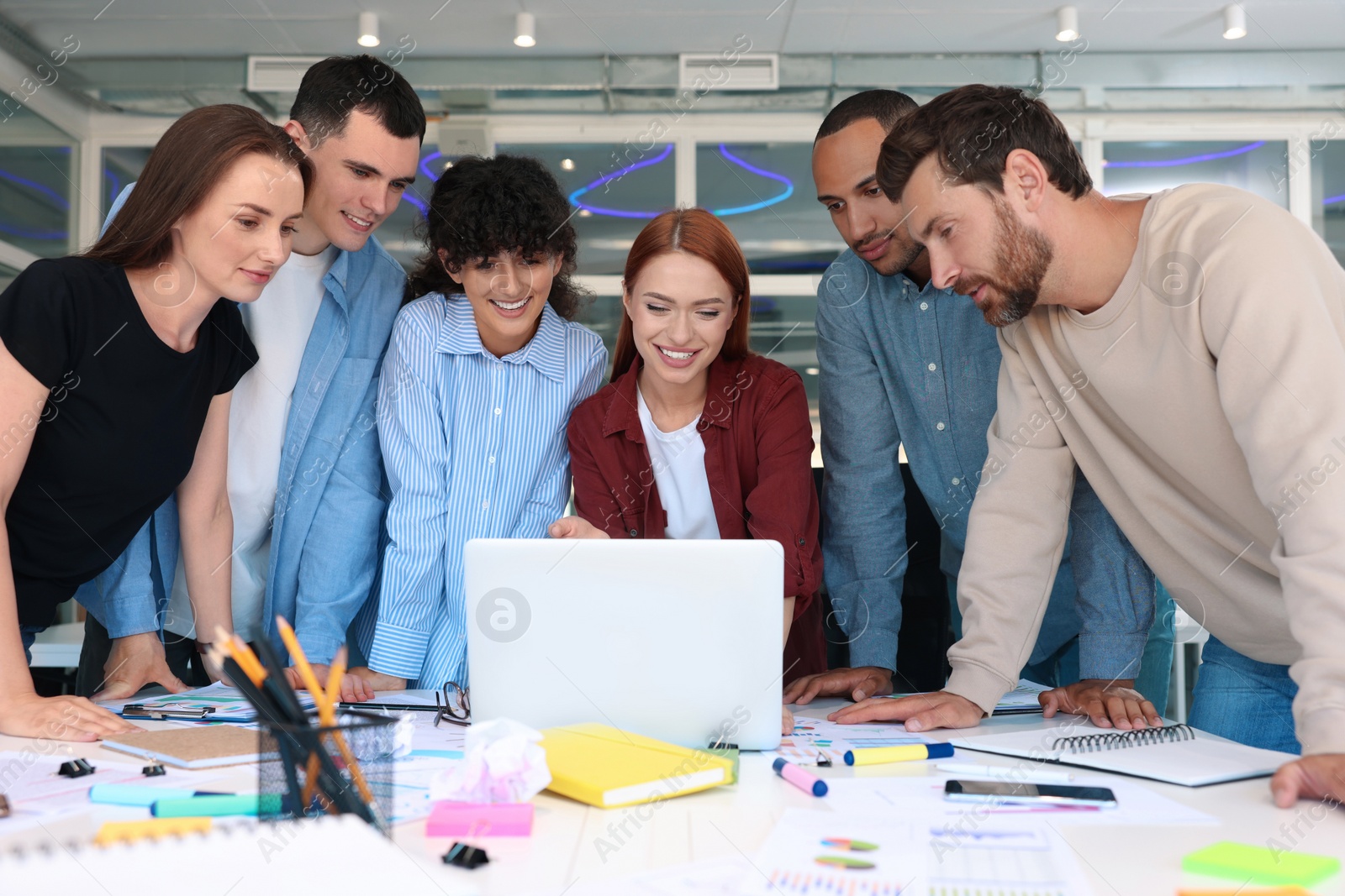 Photo of Team of employees working together at table in office. Startup project