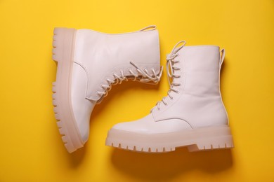 Photo of Pair of stylish shoes on yellow background, flat lay