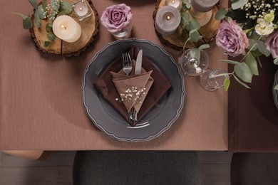 Photo of Elegant table setting with beautiful floral decor and burning candles, top view