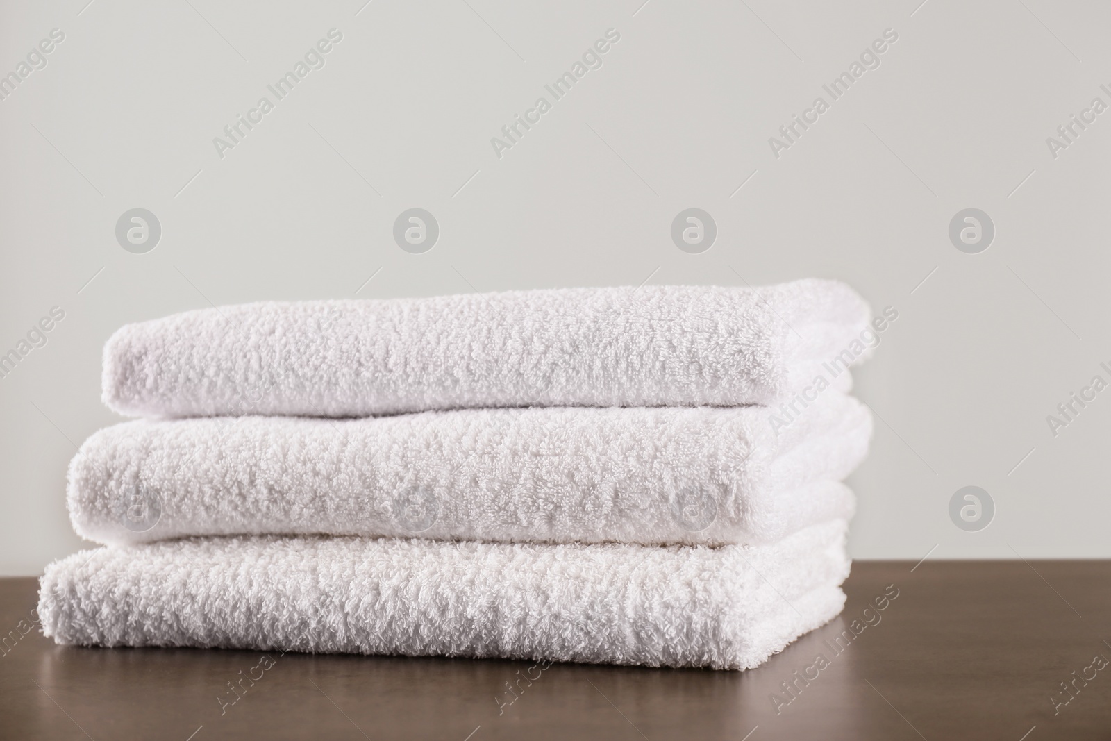 Photo of Stack of clean bath towels on dark grey table