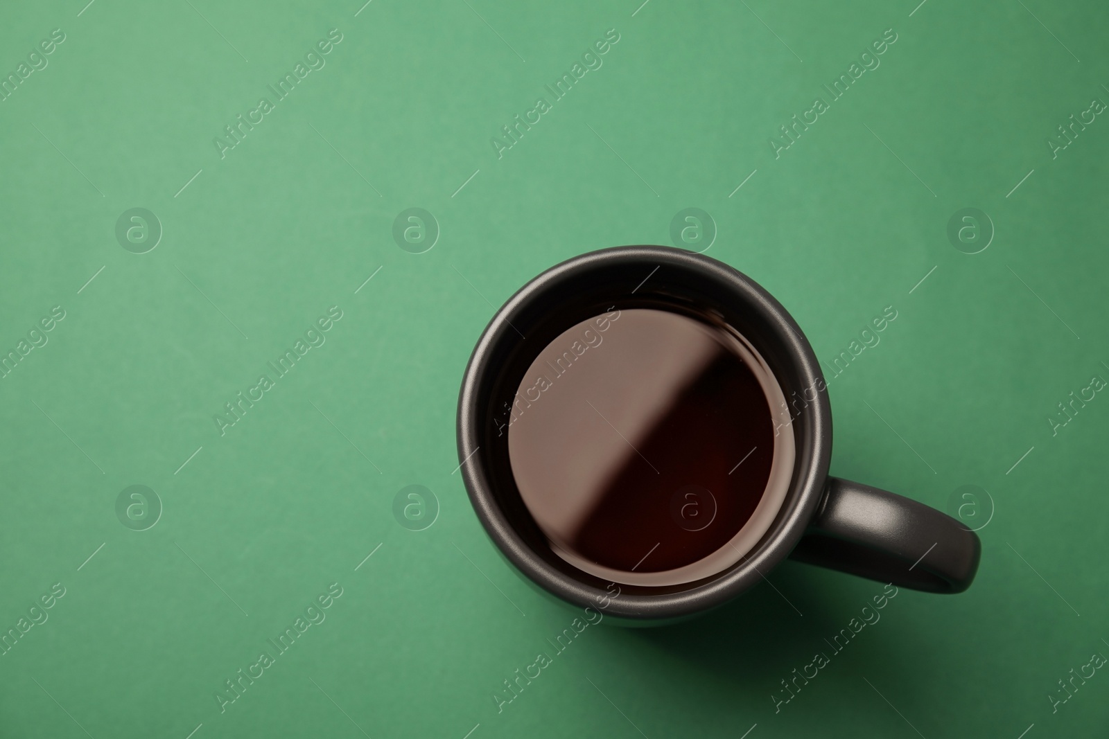 Photo of Cup of black tea on color background, top view