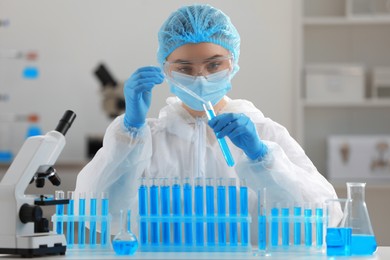 Scientist dripping sample into test tube in laboratory