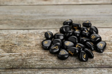 Pile of black rune stones on wooden table