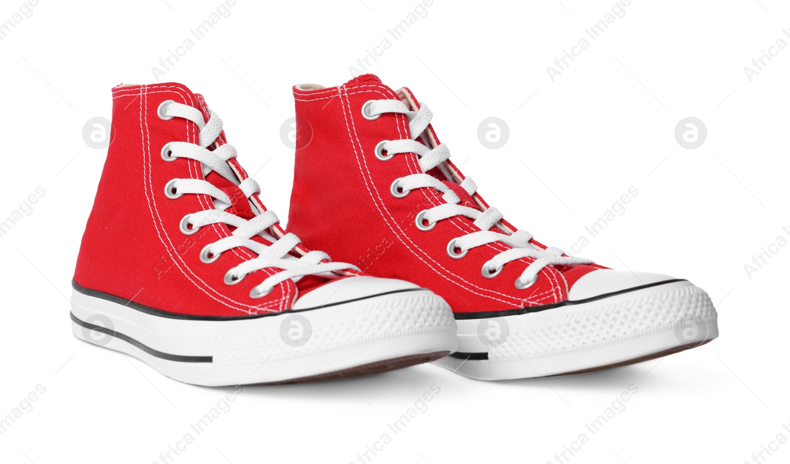 Photo of Pair of new red stylish high top plimsolls on white background