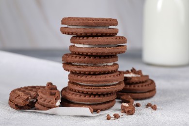 Tasty chocolate sandwich cookies with cream on light grey table, closeup