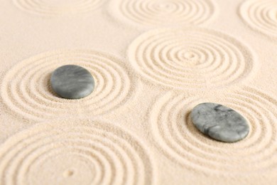 Photo of Zen garden stones on beige sand with pattern