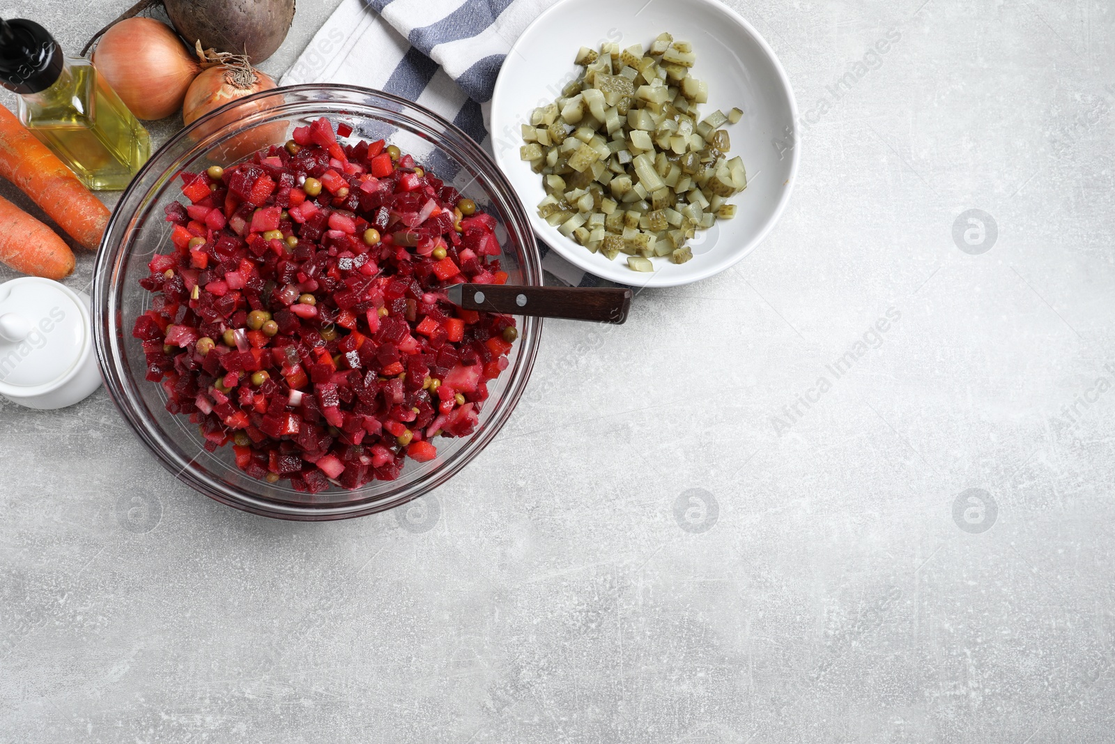 Photo of Delicious fresh vinaigrette salad and ingredients on light grey table, flat lay. Space for text