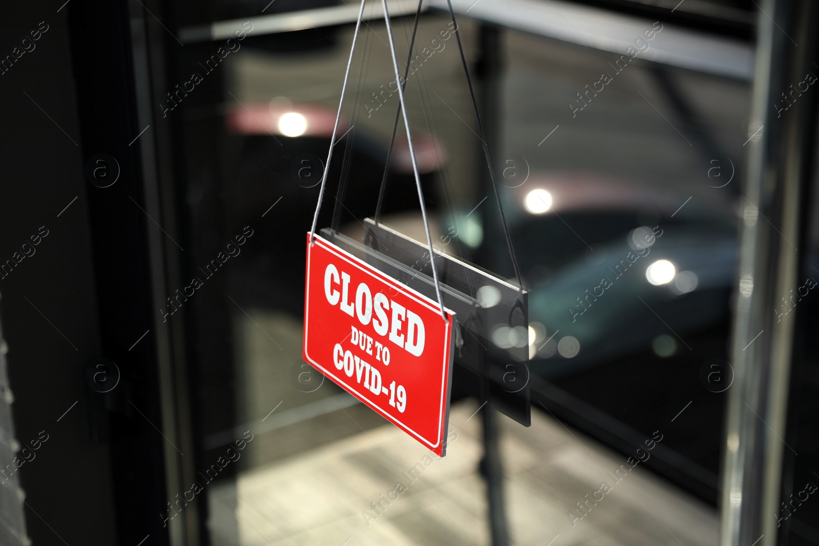 Photo of Red sign with text Closed Due To Covid-19 hanging on glass door. Coronavirus quarantine