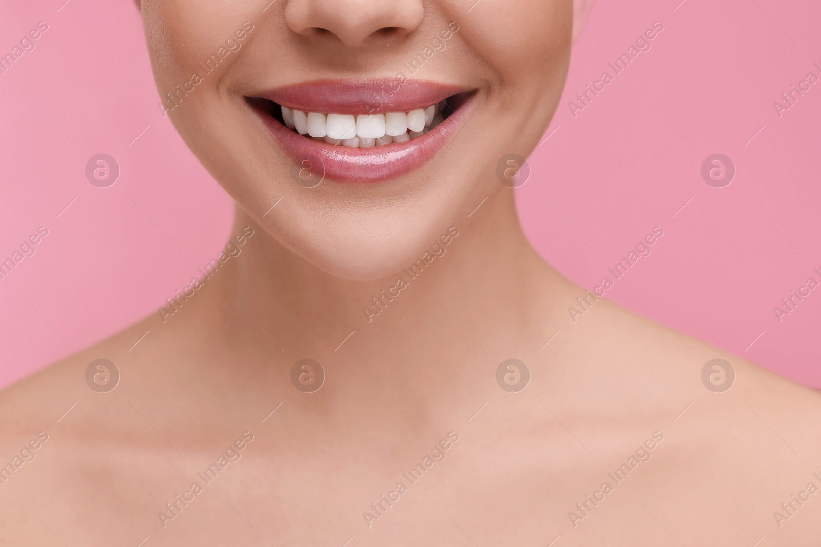 Photo of Woman with beautiful lips smiling on pink background, closeup