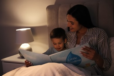 Mother reading bedtime story to her son at home